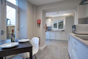 a kitchen with white cabinets and a table with chairs at The Hideaway with Cosy Fireplace by LetMeStay in Ambleside