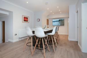 a dining room with a table and white chairs at Redbanks Apartment in Ambleside