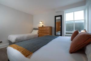 1 Schlafzimmer mit 2 Betten, einer Kommode und einem Fenster in der Unterkunft Redbanks Apartment in Ambleside