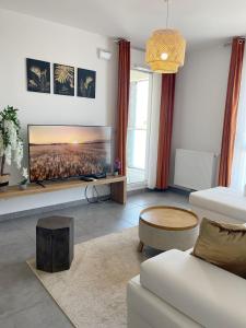 a living room with a white couch and a tv at Rare ***Centre ville * Parking in Montpellier