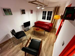 - un salon avec un canapé et des fauteuils rouges dans l'établissement Loft Villaviciosa, à Villaviciosa