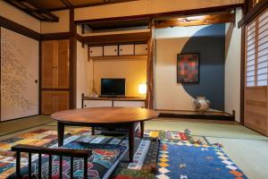 a living room with a table and a rug at Tsukasa Ryokan in Saga