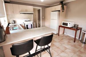 een keuken met een aanrecht en een aantal stoelen. bij Spacious 3 bedrooms Duplex Free parking in Liverpool