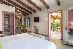 a bedroom with a white bed and a living room at Finca Can Marti in Alcudia