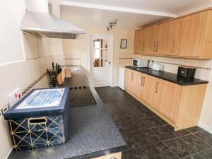 a kitchen with wooden cabinets and a counter top at Brynawel in Carmarthen