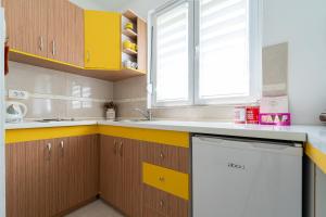 a kitchen with yellow cabinets and a white dishwasher at Apartments Gruda in Cetinje +43 photos