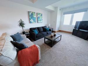 een woonkamer met een bank en een tv bij 3BR Luxury Suite with Parking at The Grand Castle in Grandville