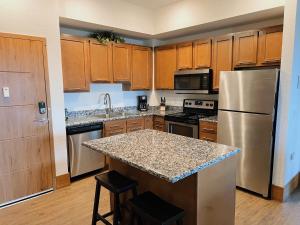een keuken met roestvrijstalen apparatuur en houten kasten bij 3BR Luxury Suite with Parking at The Grand Castle in Grandville +28 foto's