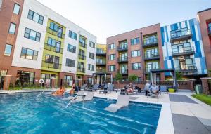 een groep mensen die rond een zwembad in een gebouw zitten bij Vibrant 2BR Corner Suite and Free Parking at CityWay in Indianapolis