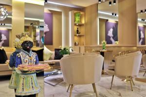 two pictures of a hotel lobby with a statue in the foreground at Hotel Le Fouquet's in Cannes