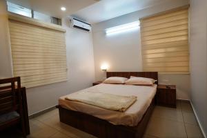 a bedroom with a bed and a window with blinds at Kadampanattu's Homestay in Ernakulam