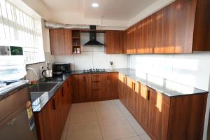 a kitchen with wooden cabinets and a counter top at Kadampanattu's Homestay in Ernakulam