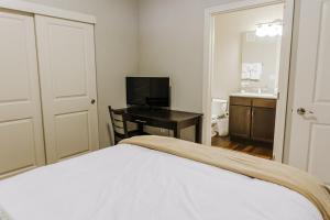a bedroom with a bed and a desk with a television at Free parking Gym & Pool Downtown at CityWay in Indianapolis
