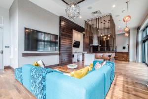a living room with a blue couch and a kitchen at Free parking Gym & Pool Downtown at CityWay in Indianapolis