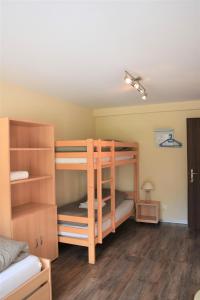two bunk beds in a room with wooden floors at Restaurant & Hostel Hole in One in Randa