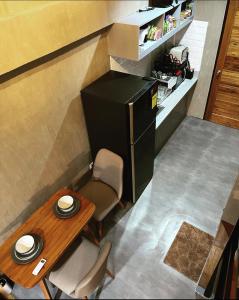 a small table and a black refrigerator in a room at 1 bedroom Apartment (Industrial Loft) in Angeles