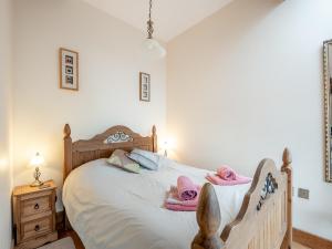 a bedroom with a bed with pink towels on it at The Granary in Bream