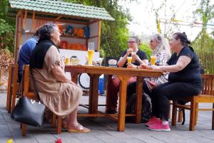 un grupo de personas sentadas alrededor de una mesa de madera en Mazhavilkadu ForestResort & Restaurant, en Kozhikode