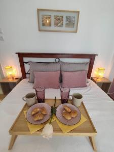 a tray with two plates of donuts on a bed at Haris modern apt. near the sea in Thessaloniki