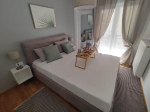 a large white bed in a room with a window at Haris modern apt. near the sea in Thessaloniki