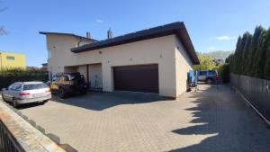 a garage with a car parked next to a building at Romainiai guest house in Kaunas