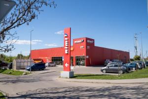 un bâtiment rouge avec des voitures garées dans un parking dans l'établissement Romainiai guest house, à Kaunas