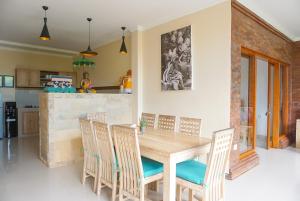 a dining room with a wooden table and chairs at Villa Semujan Ubud in Ubud