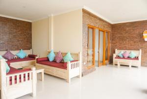 a living room with benches and a brick wall at Villa Semujan Ubud in Ubud