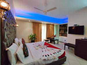 a bedroom with a large bed and a living room at Misty Meadows, Lonavala in Lonavala