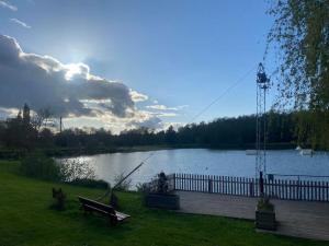 a person sitting on a bench next to a lake at Appartement 2 in Les Minières