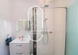 baño con ducha y puerta de cristal en Villa Antoine Appartement RDJ Vue mer CLiM Wifi parking plage 50m La Garonne, en Le Pradet