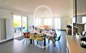 een keuken en eetkamer met een tafel en stoelen bij Villa Antoine Appartement RDJ Vue mer CLiM Wifi parking plage 50m La Garonne in Le Pradet