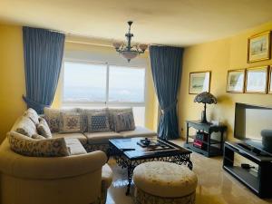 a living room with a couch and a large window at Villa Romeo, with brand new salt water pool in Benalmádena