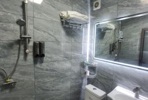 uma casa de banho com um lavatório, um espelho e um WC. em Haikou Banana Hostel em Haikou
