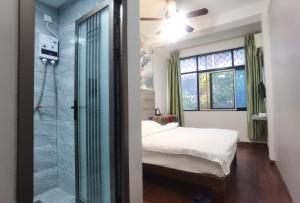 海口市にあるハイコウ バナナ ホステルのベッドルーム1室(ベッド1台、ガラス張りのシャワー付)