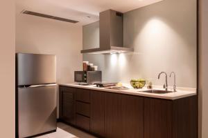 a kitchen with a sink and a refrigerator at Oakwood Hotel and Residence Kuala Lumpur in Kuala Lumpur