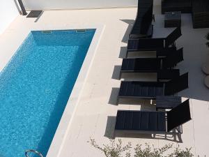 an overhead view of a swimming pool with lounge chairs and a swimming pool at Apartments Batur in Zadar