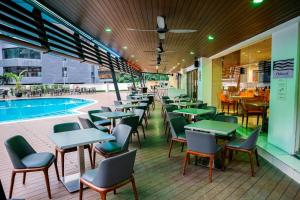 a restaurant with tables and chairs next to a pool at Oakwood Hotel and Residence Kuala Lumpur in Kuala Lumpur