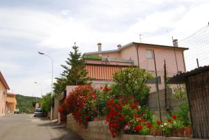 una cerca con flores rojas delante de una casa en Tanca is Torus, en Teulada