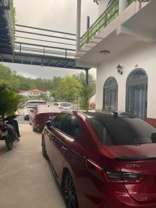 ein rotes Auto, das vor einem Haus parkt in der Unterkunft Nhà Nghỉ Blue Sapphire - hotel in Xuyên Mộc