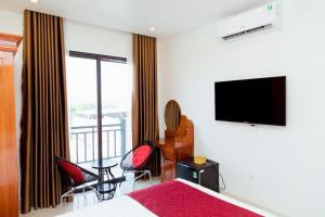Schlafzimmer mit einem Bett und einem Flachbild-TV in der Unterkunft Vĩnh Sơn Nội Bài in Hanoi