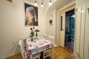 a dining room with a table and a painting of a woman at Downtown secret apartment in Zagreb