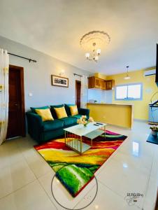 a living room with a green couch and a colorful rug at RESIDENCE LUXALYS in Yaoundé