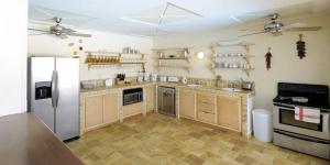 a kitchen with wooden cabinets and a refrigerator at Spacious villa with sea view in Saint Martin + private pool. in Les Terres Basses