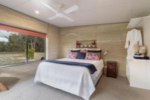 a bedroom with a large bed and a window at Earth & Soul Retreat in Cannon Creek +48 photos