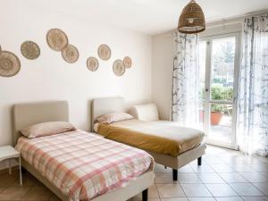 2 Betten in einem Schlafzimmer mit Spiegeln an der Wand in der Unterkunft Agriturismo Familiare I Giardini del Lago in Varese