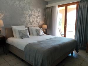 a bedroom with a large bed and a window at La Ruelle Van Uchelen in Beaufort