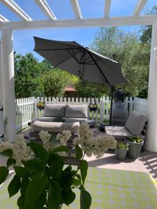 尚塞拉德的住宿－Brigitte et Moi，一个带沙发和遮阳伞的庭院