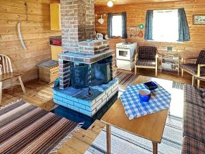 uma sala de estar com lareira num chalé de madeira em Two-Bedroom Holiday home in Farsund 1 em Helle