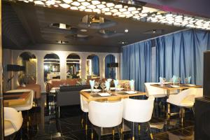 a restaurant with tables and chairs and blue curtains at Nomado Boutique Hotel in Ulaanbaatar
